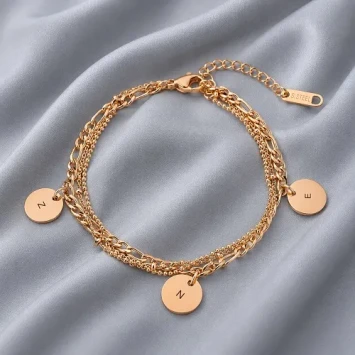 Armband in rosé kleur met 3 verschillende bandjes en 3 ronde bedels